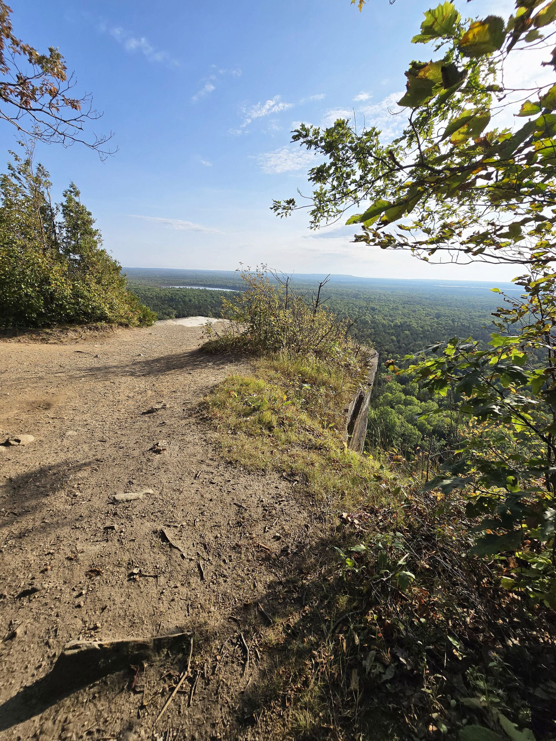 A view from the Cup and saucer trail, overlooking a cliff to the forest and distant lakes below.