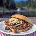 A Puttanesca sloppy joe on a ciabatta roll with black olives, capers, and parmesan cheese visible.
