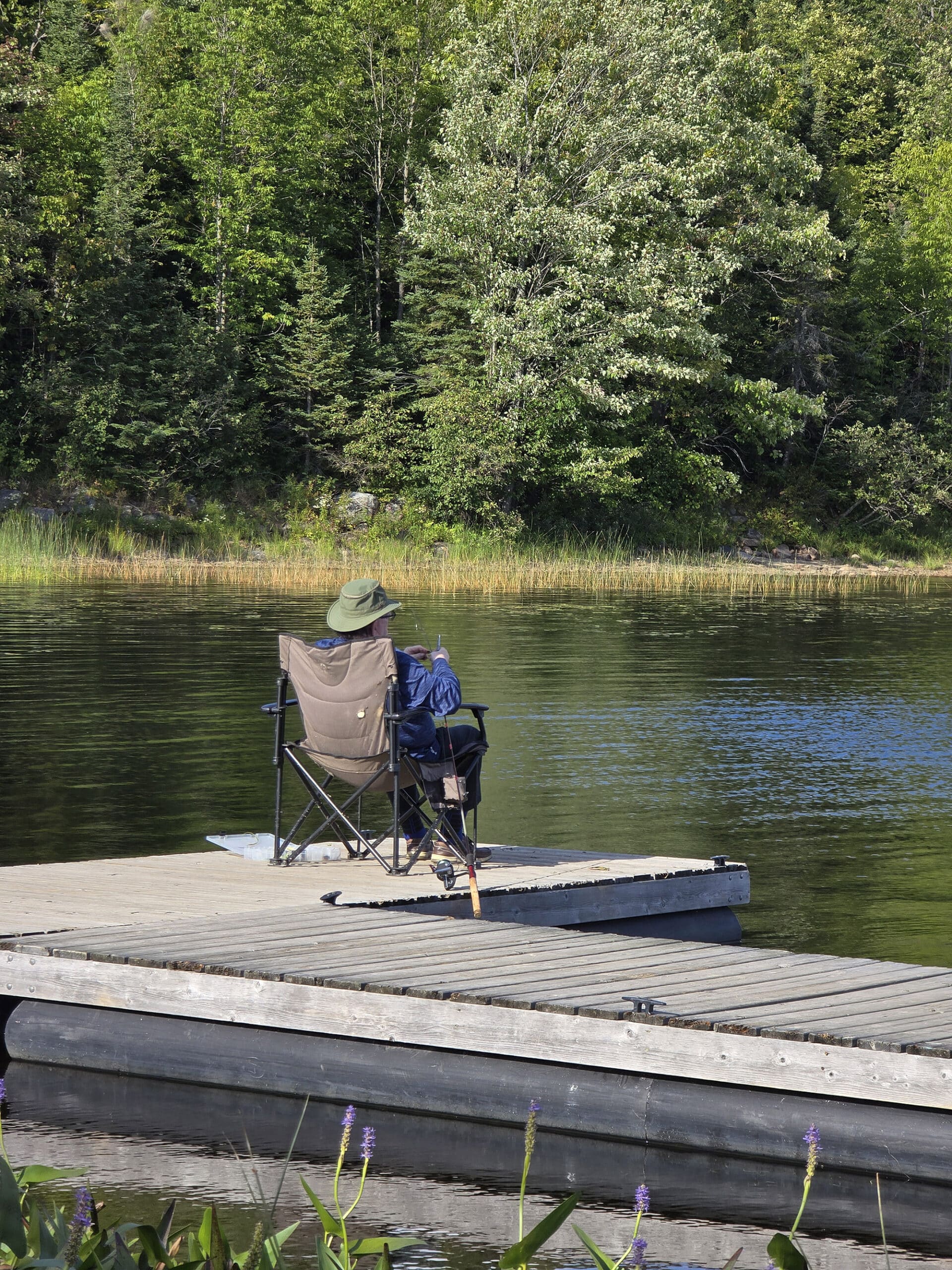 A man fishing from a dock on Restoule Lake