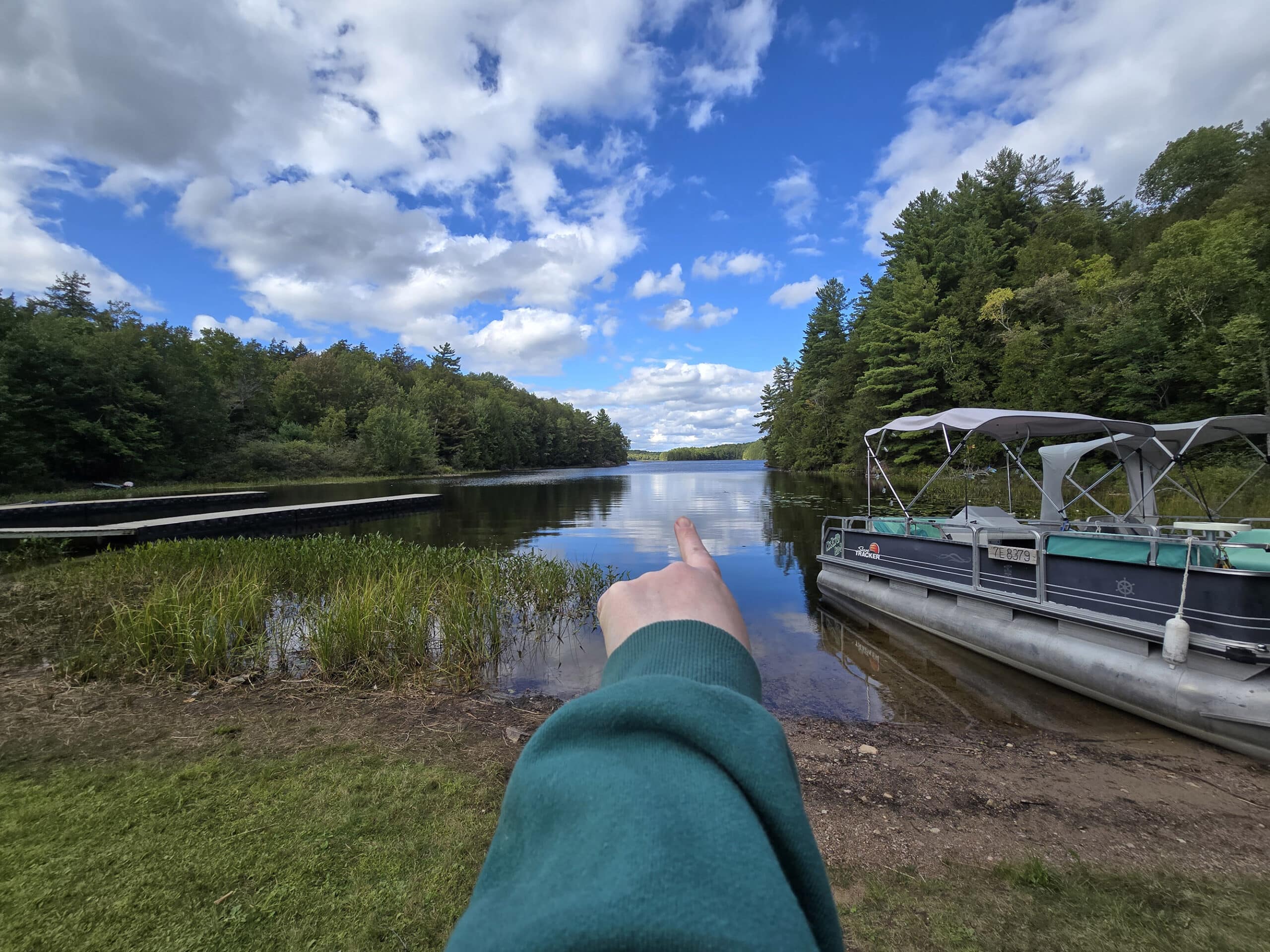 A hand pointing north at the boat launch onto stormy lake at Restoule Provincial Park.