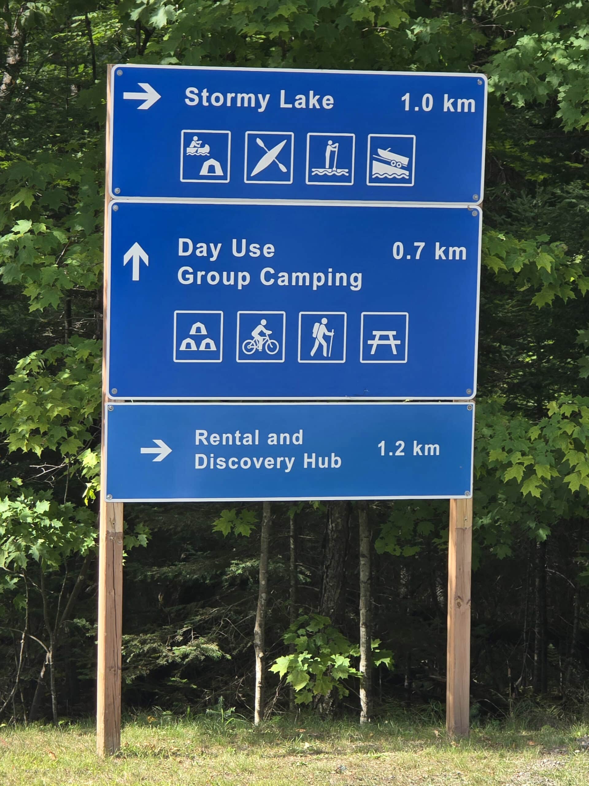 A blue and white directional campground road sign.
