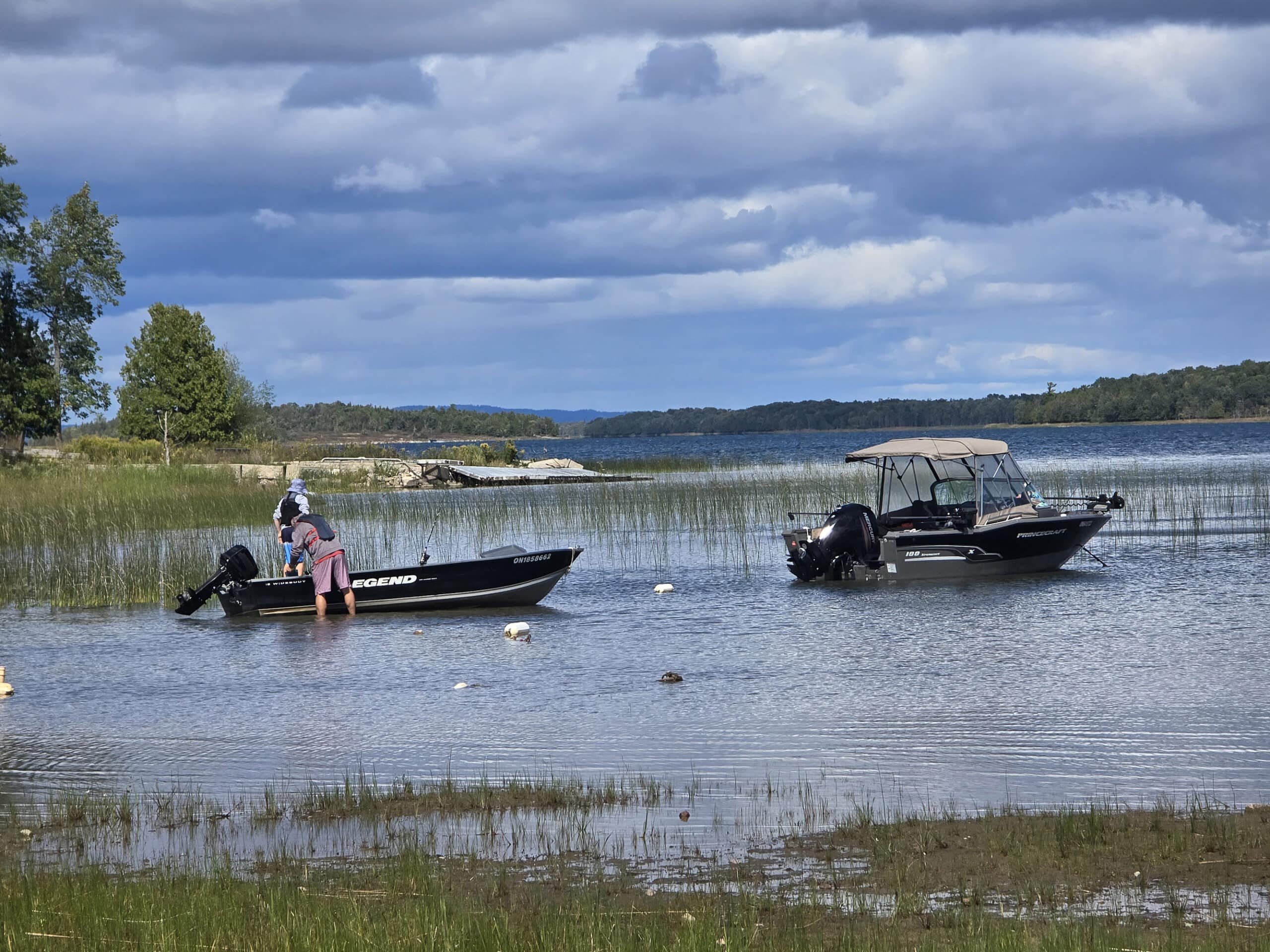 2 small boats on sunrise beach at Batmans Cottages and Campground.