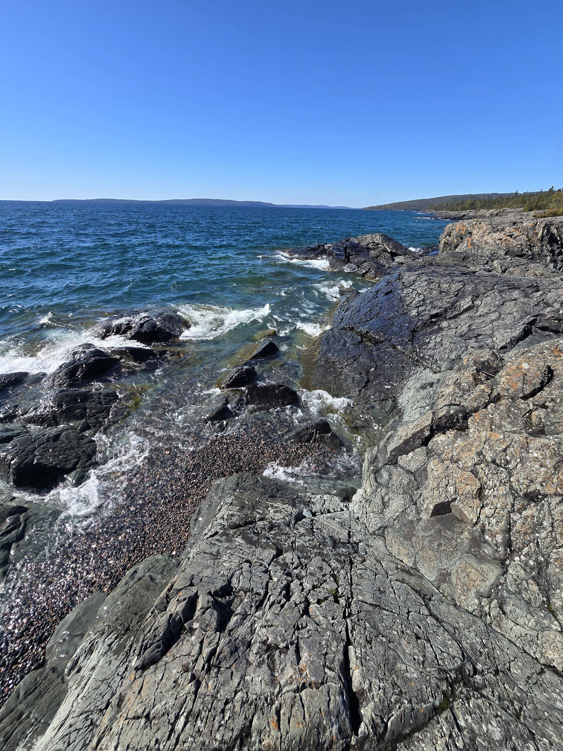 Schreiber Beach, a rocky lake superior beach with glistening blue water.