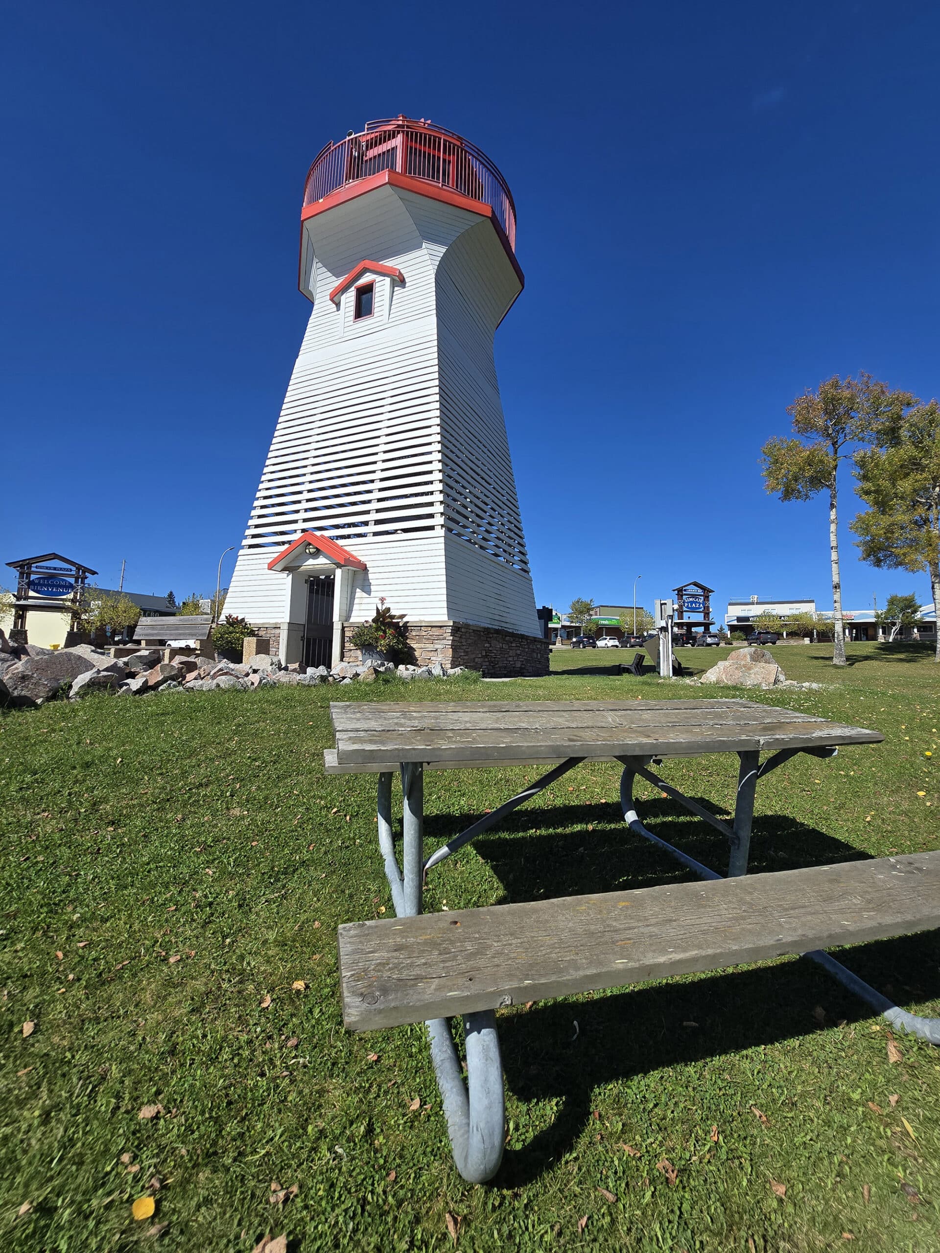 The terrace bay lighthouse, with a picnic table in front of it.