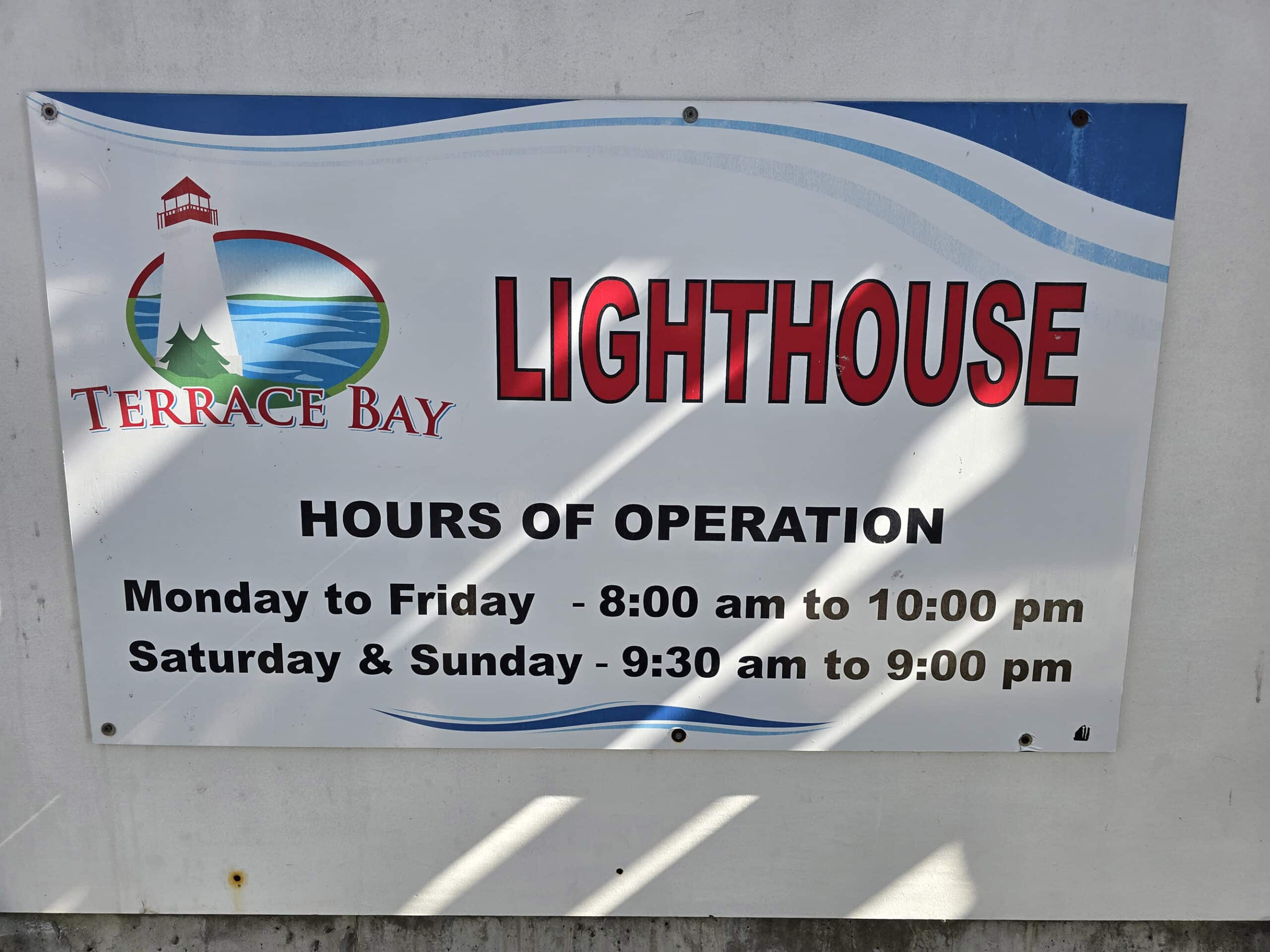 A sign indicating the hours at the terrace bay lighthouse.