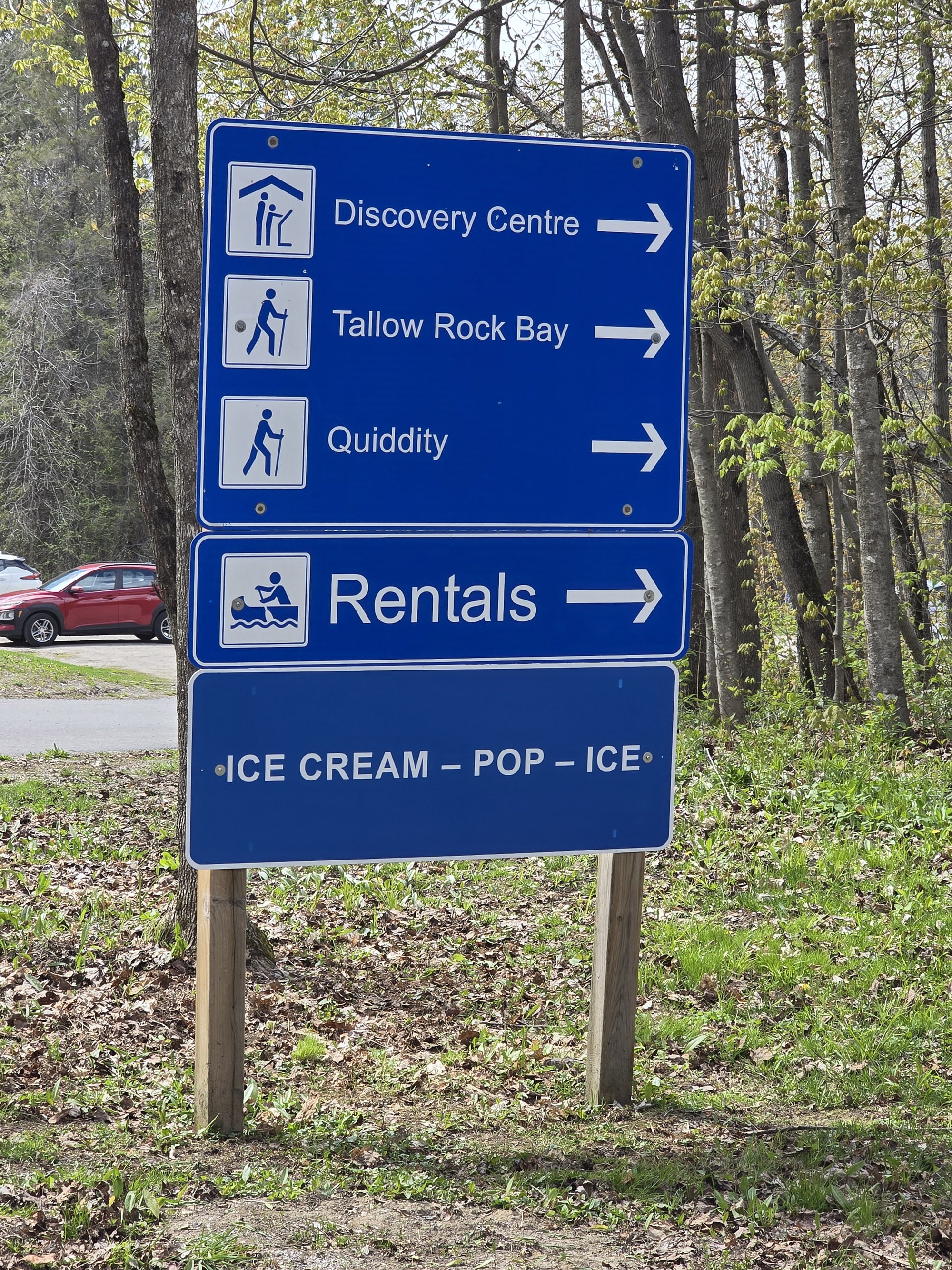 A blue and white directional sign at charleston lake provincial park.