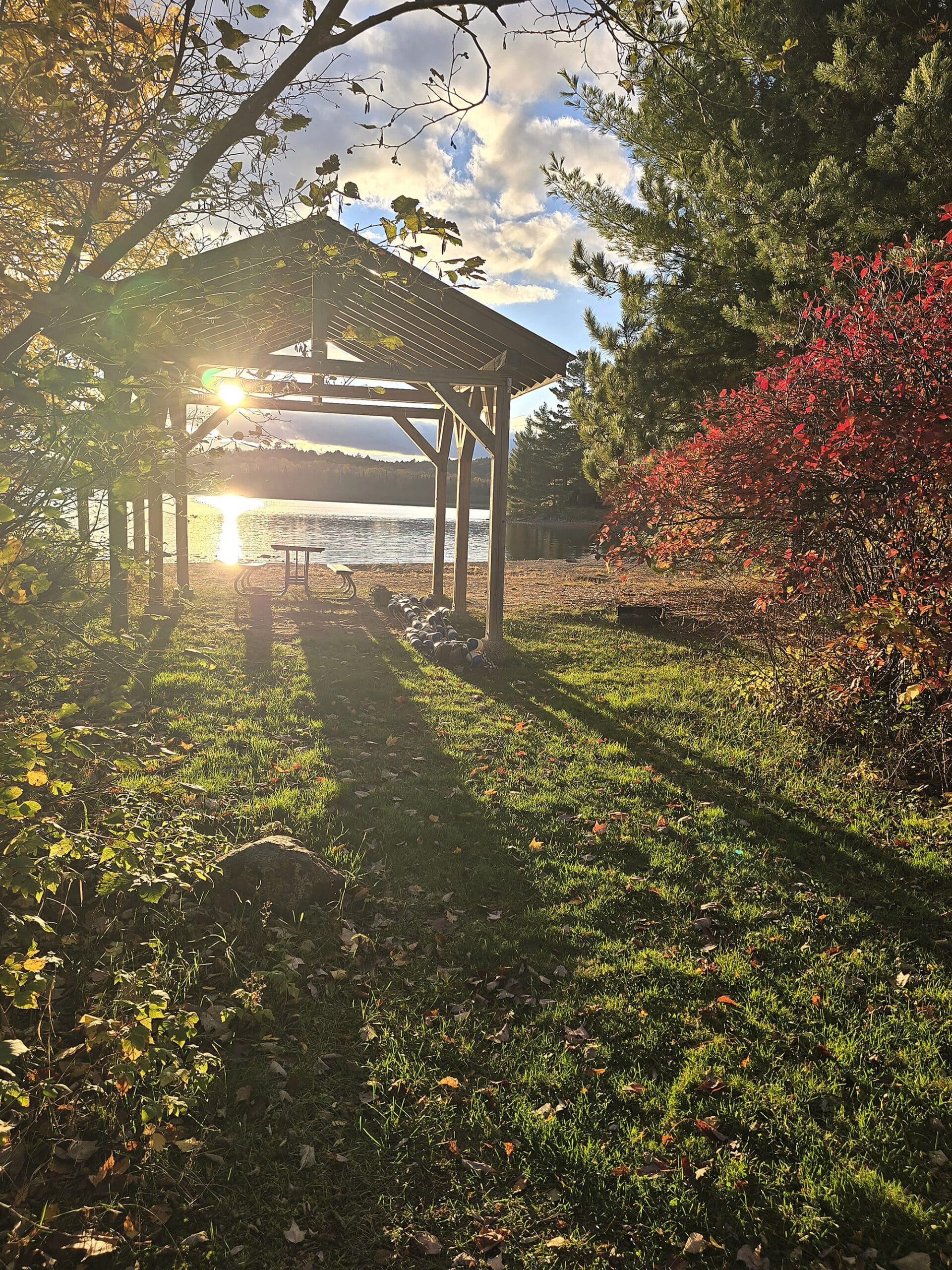 A small picnic shelter with a sunbeam coming through it.