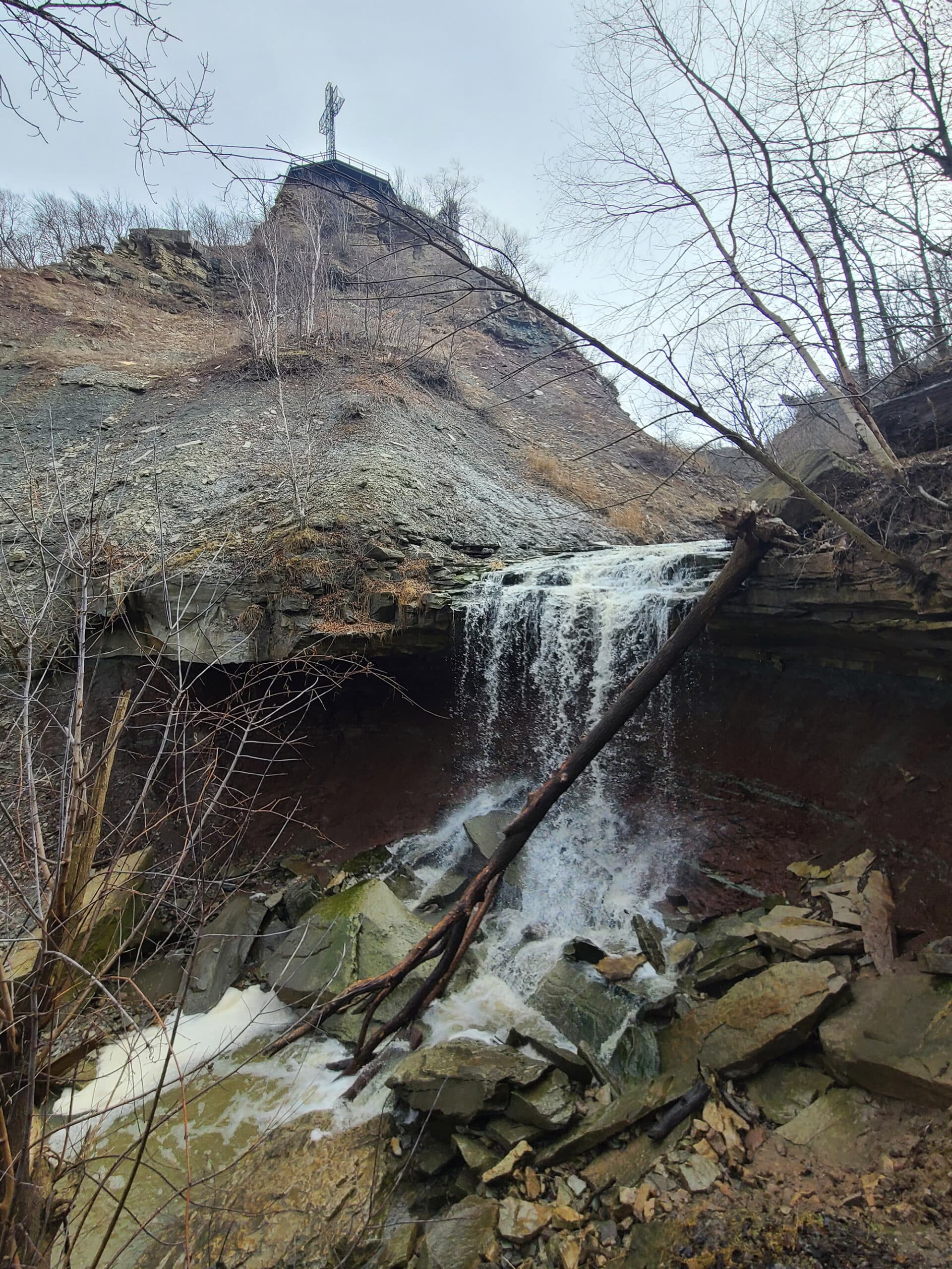 The lower waterfall and Devil’s punchbowl, with the viewing platform and cross up high in the distance behind it.
