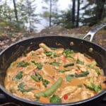 A pan of peanut butter chicken stir fry with a variety of colourful vegetables in it.