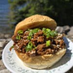 A Korean Beef Sloppy Joes sandwich with green onions and sesame seeds.