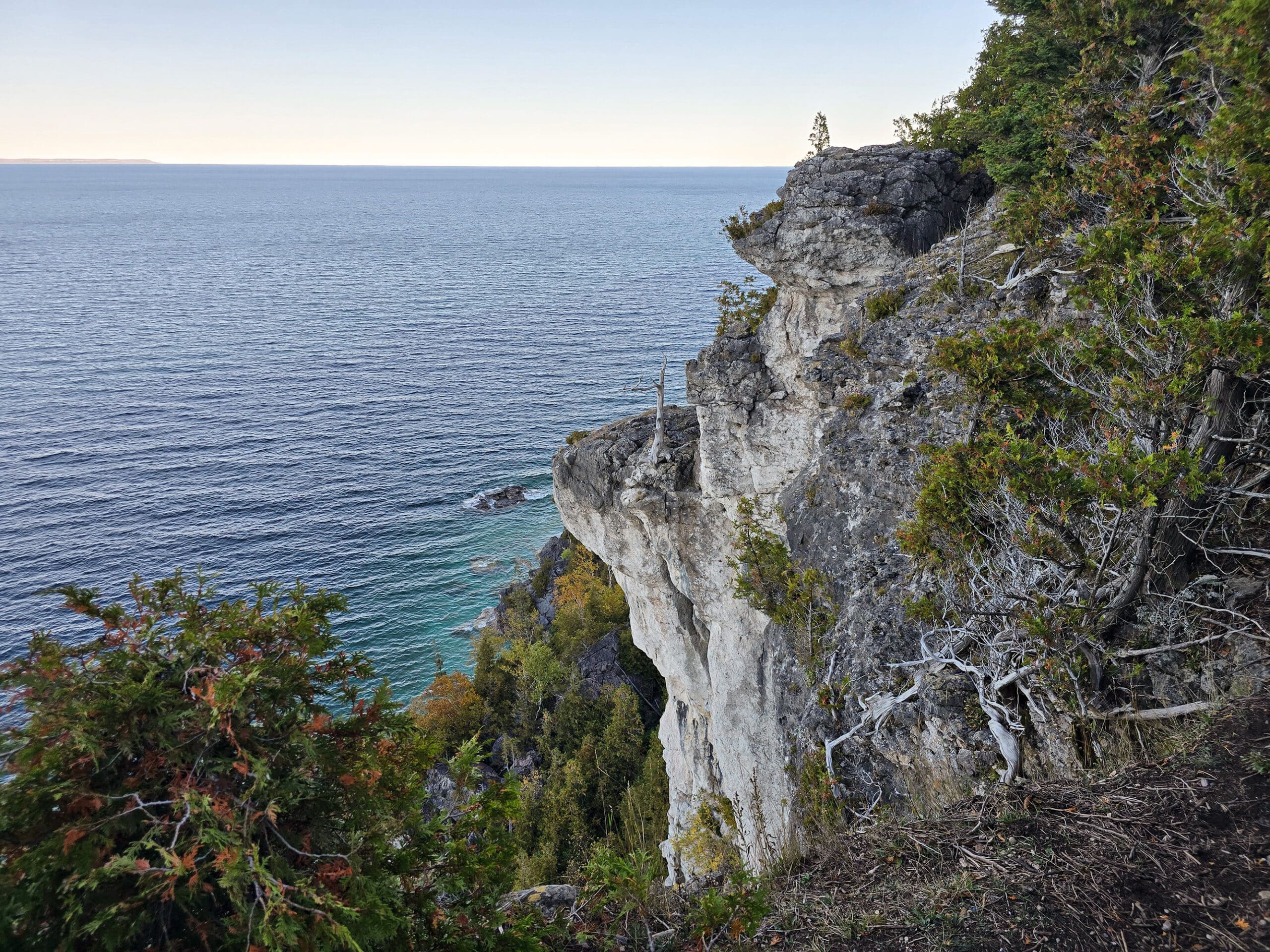 A side view of lions head lookout, a large rock formation with Georgian Bay in the background.