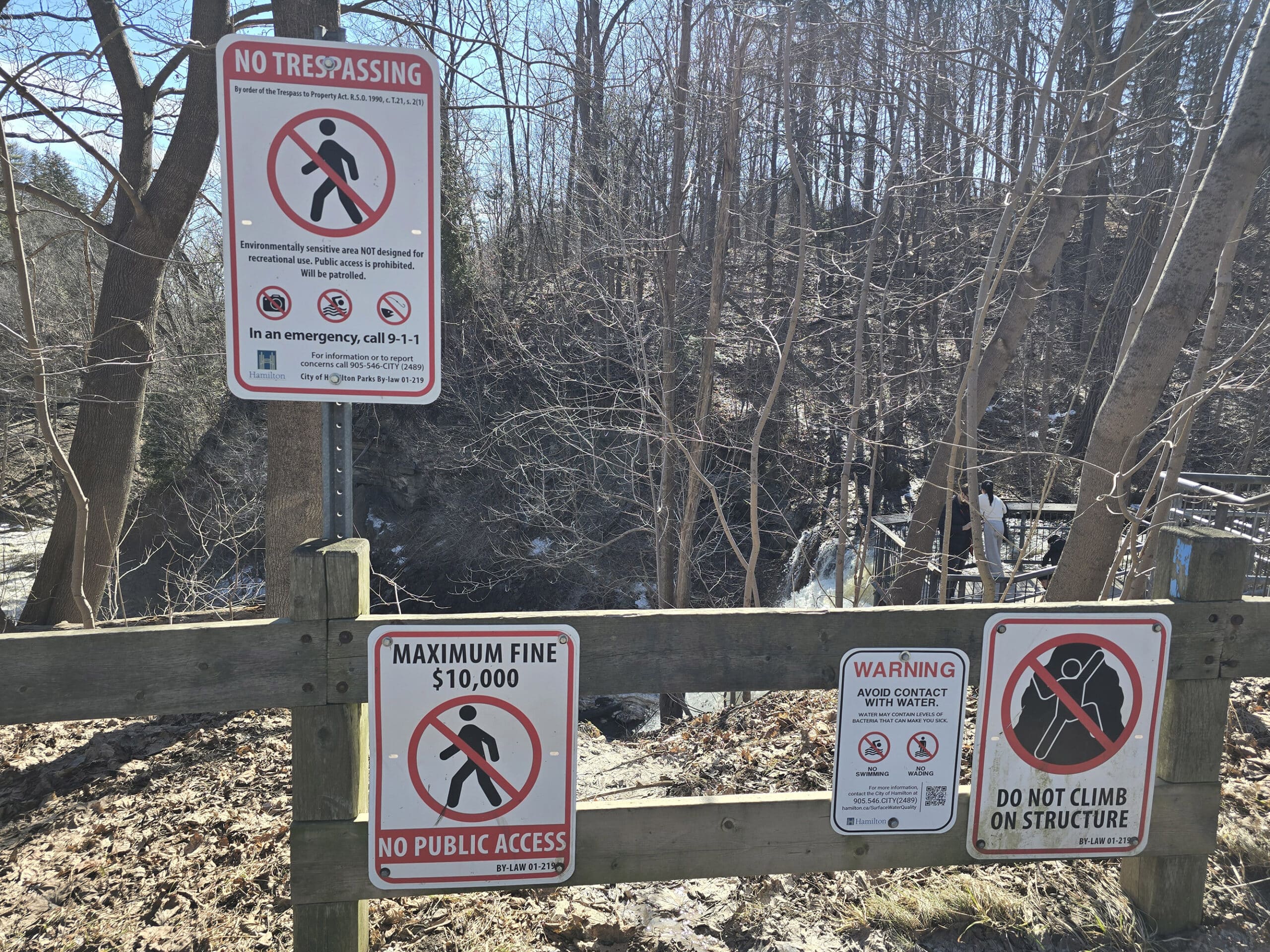 Warning signage on a fence at Smokey Hollow Falls.