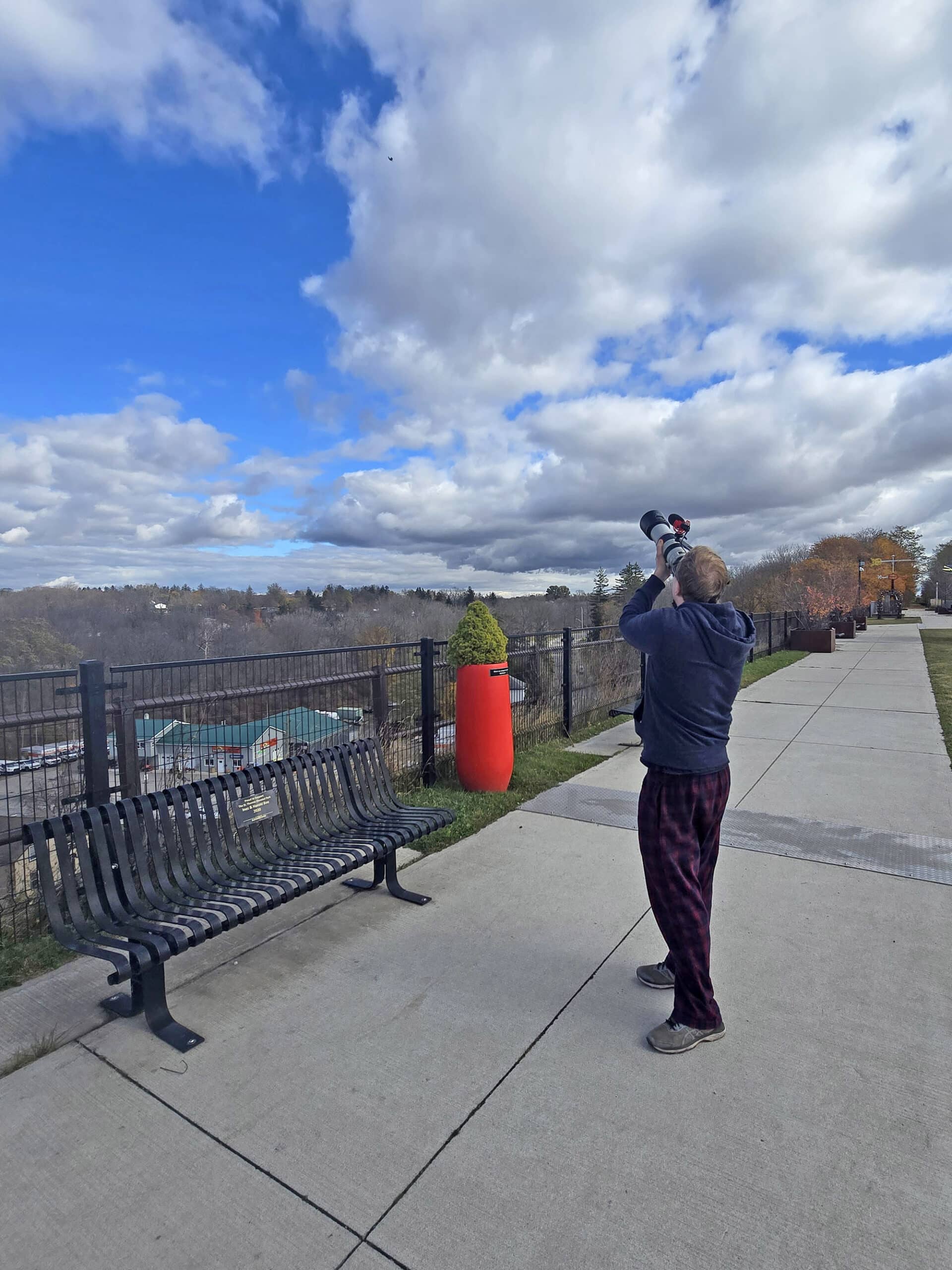 A blonde middled aged man photographing birds from the st thomas elevated park.