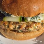 A Mediterranean fresh salmon burger with lemon, dill, and feta in it, and zucchini ribbons on top.