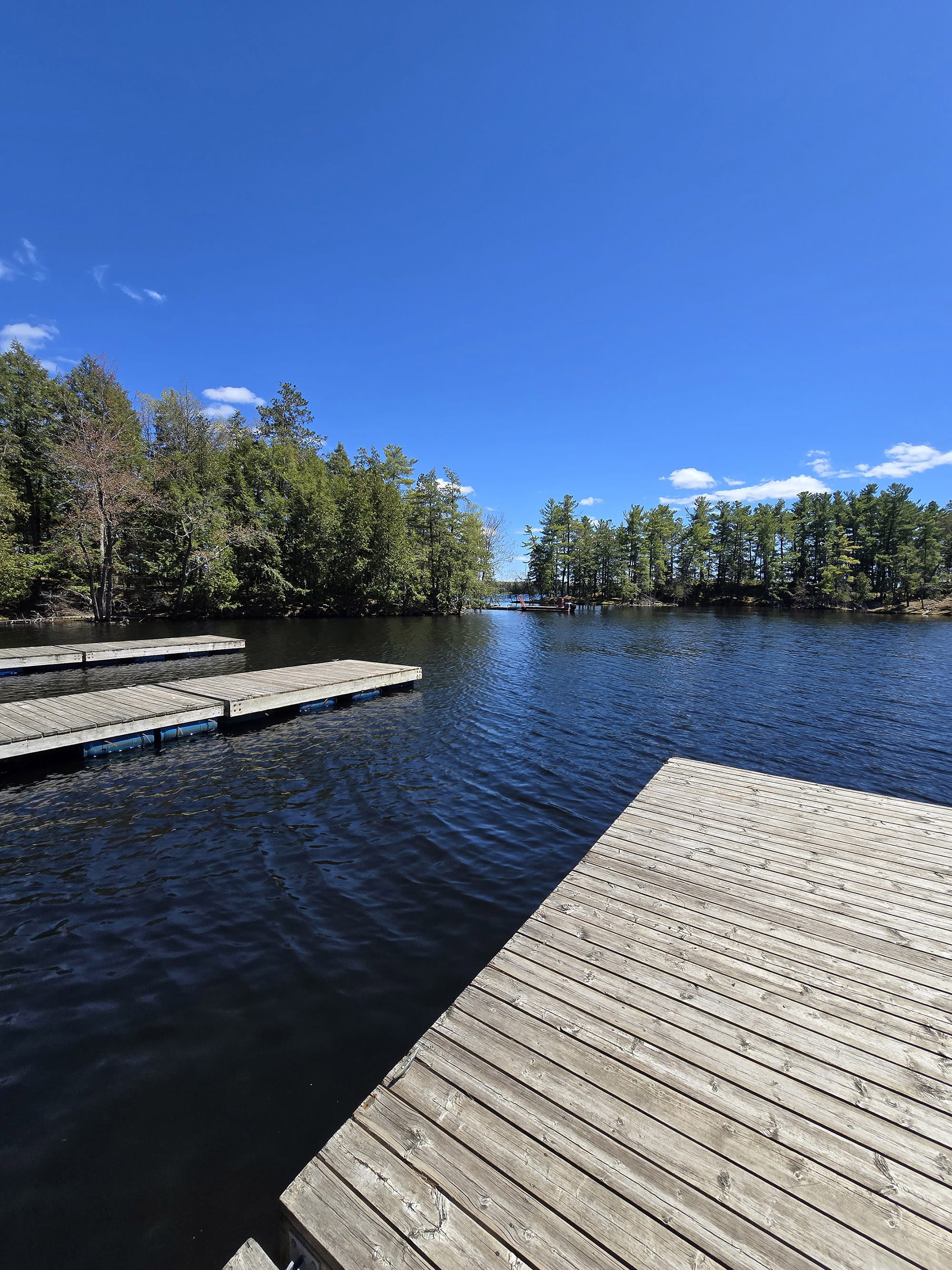 A set of wooden docks on a blue lake.
