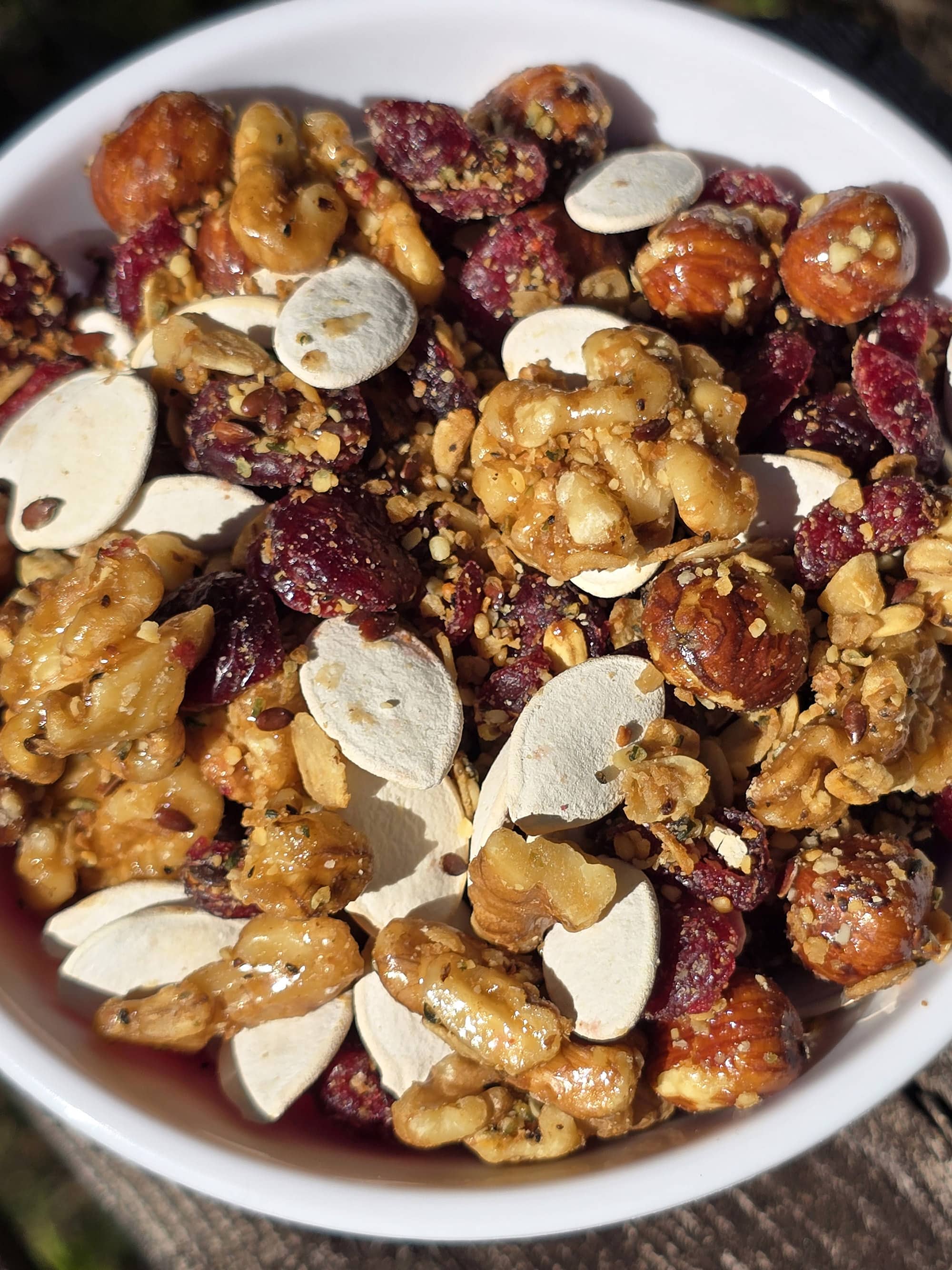 A bowl of Canada day trail mix, with maple glazed nuts, dried cranberries, maple granola, and pumpkin seeds.