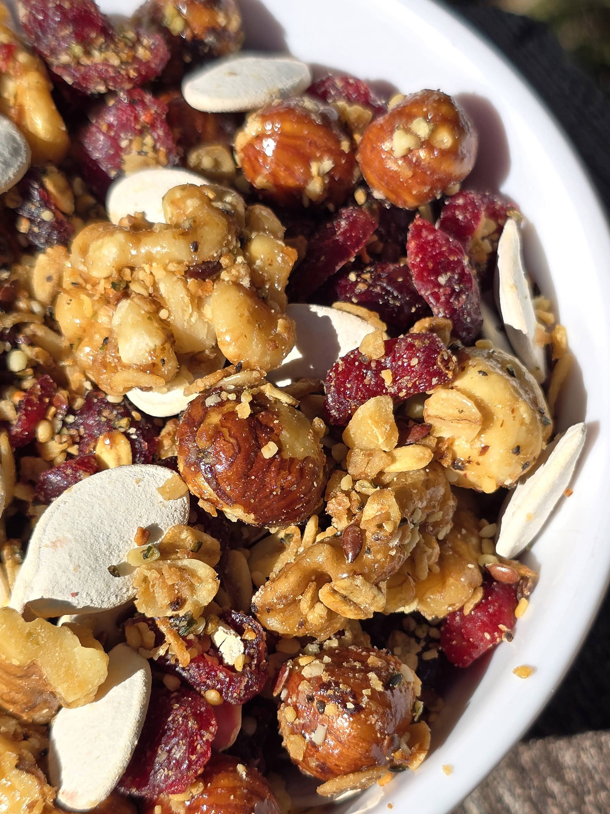 A bowl of Canada day trail mix, with maple glazed nuts, dried cranberries, maple granola, and pumpkin seeds.