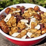 A bowl of Canadian trail mix, with maple glazed nuts, dried cranberries, maple granola, and pumpkin seeds.