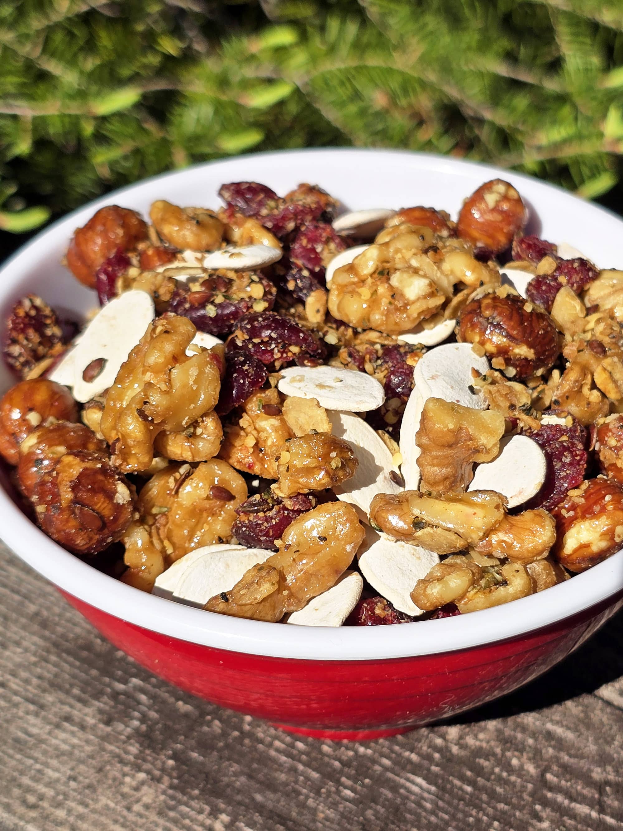 A bowl of Canadian trail mix, with maple glazed nuts, dried cranberries, maple granola, and pumpkin seeds.