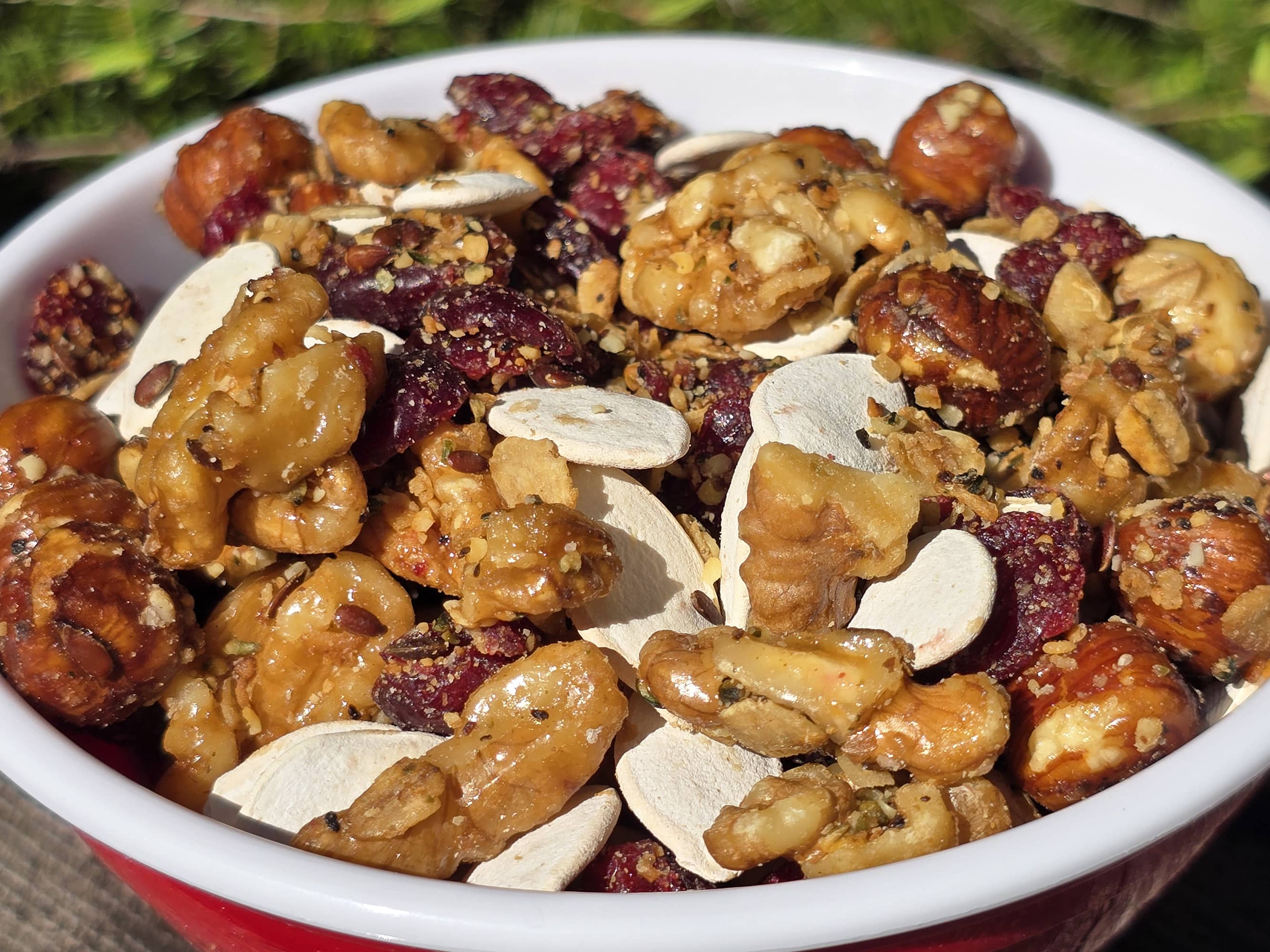 A bowl of Canadian trail mix, with maple glazed nuts, dried cranberries, maple granola, and pumpkin seeds.