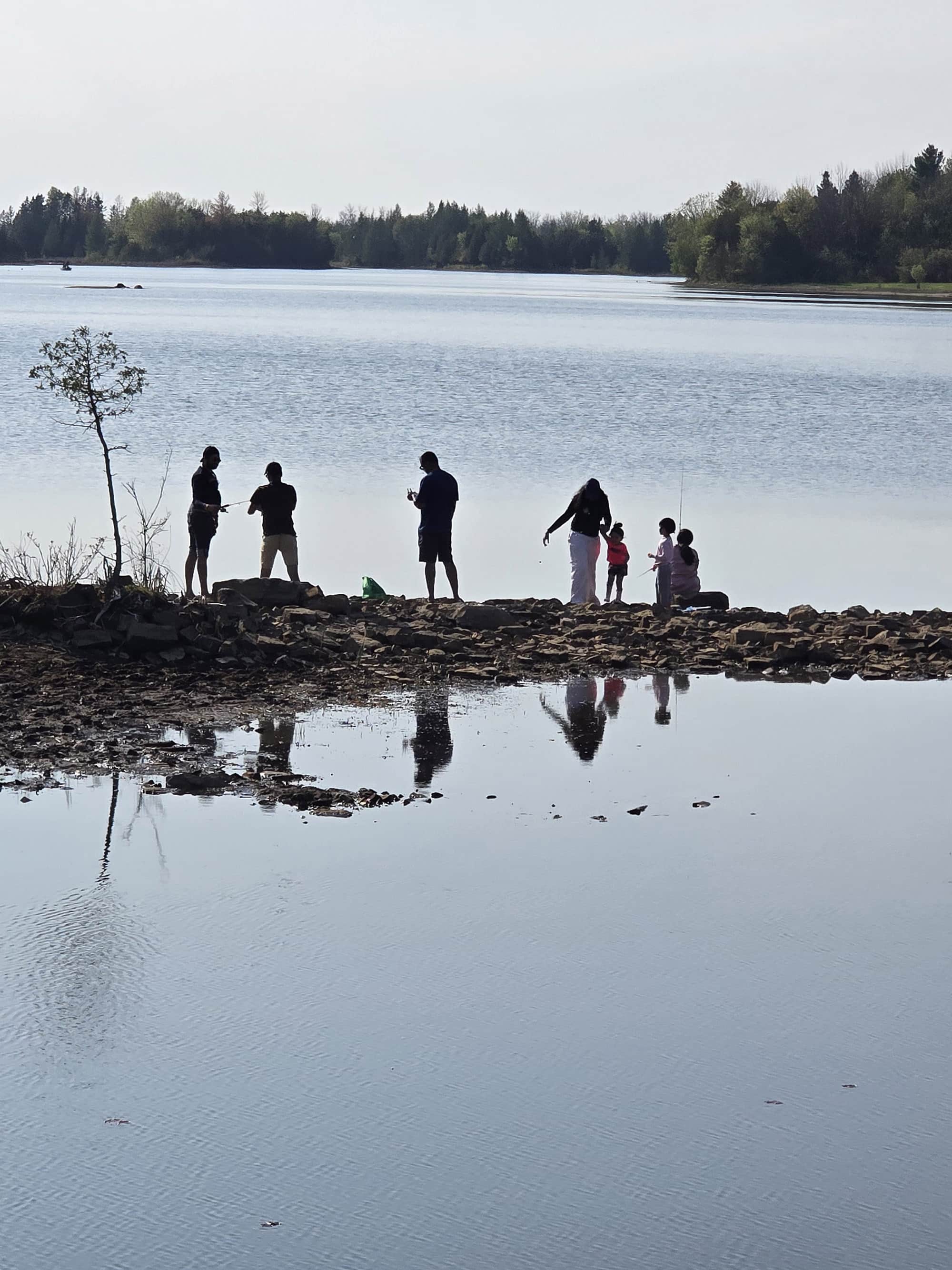 Silhouettes of a family fishing on shore at Voyageur Provincial Park.