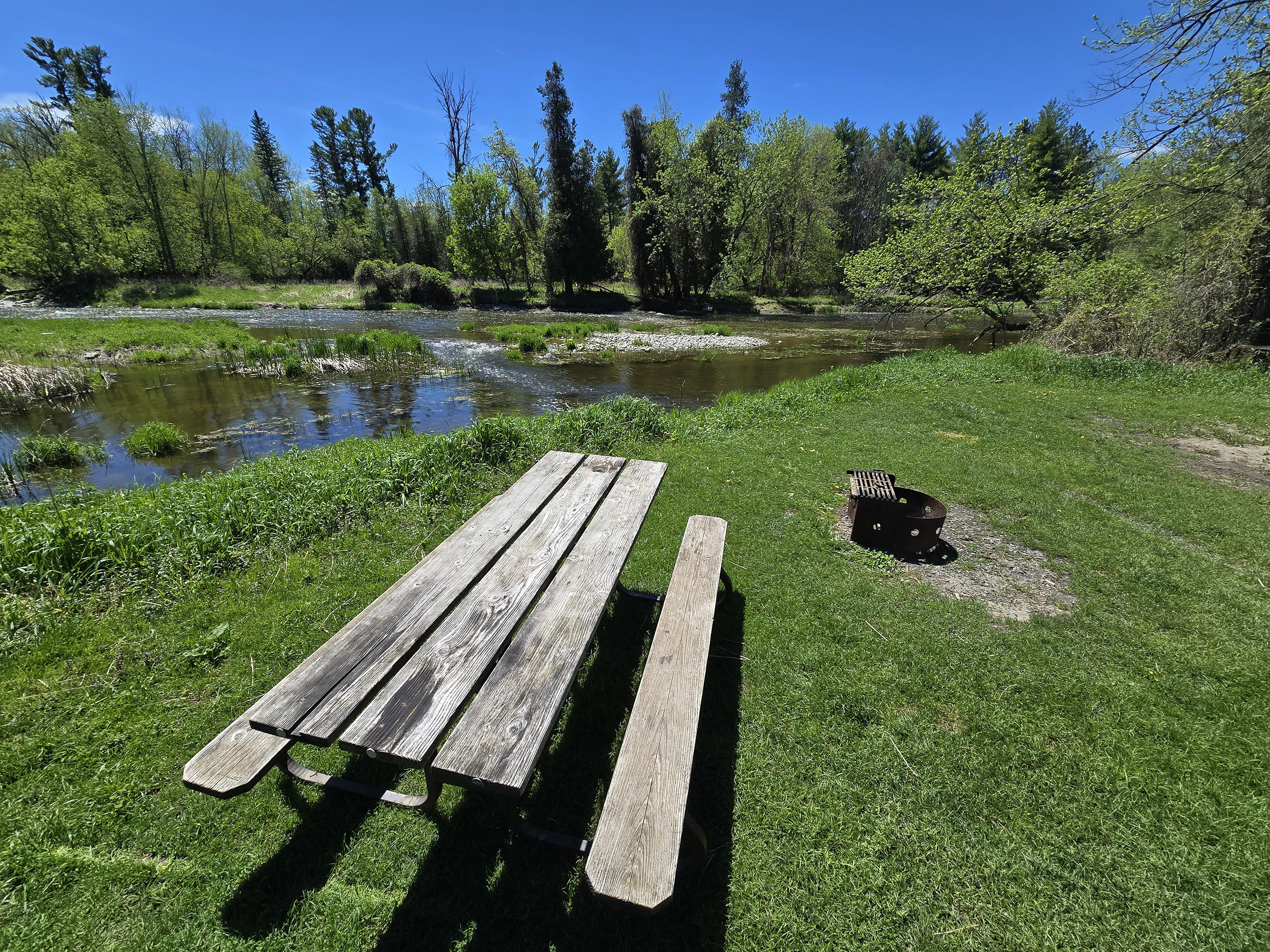 An open campsite overlooking a river.