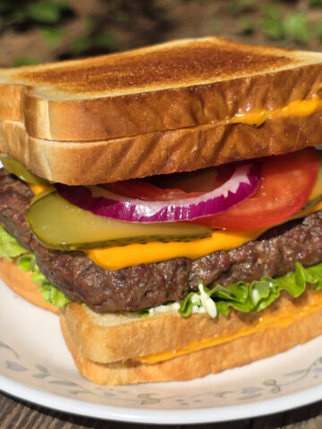 A grilled cheese cheeseburger made with a burger patty ad 2 grilled cheese sandwiches.