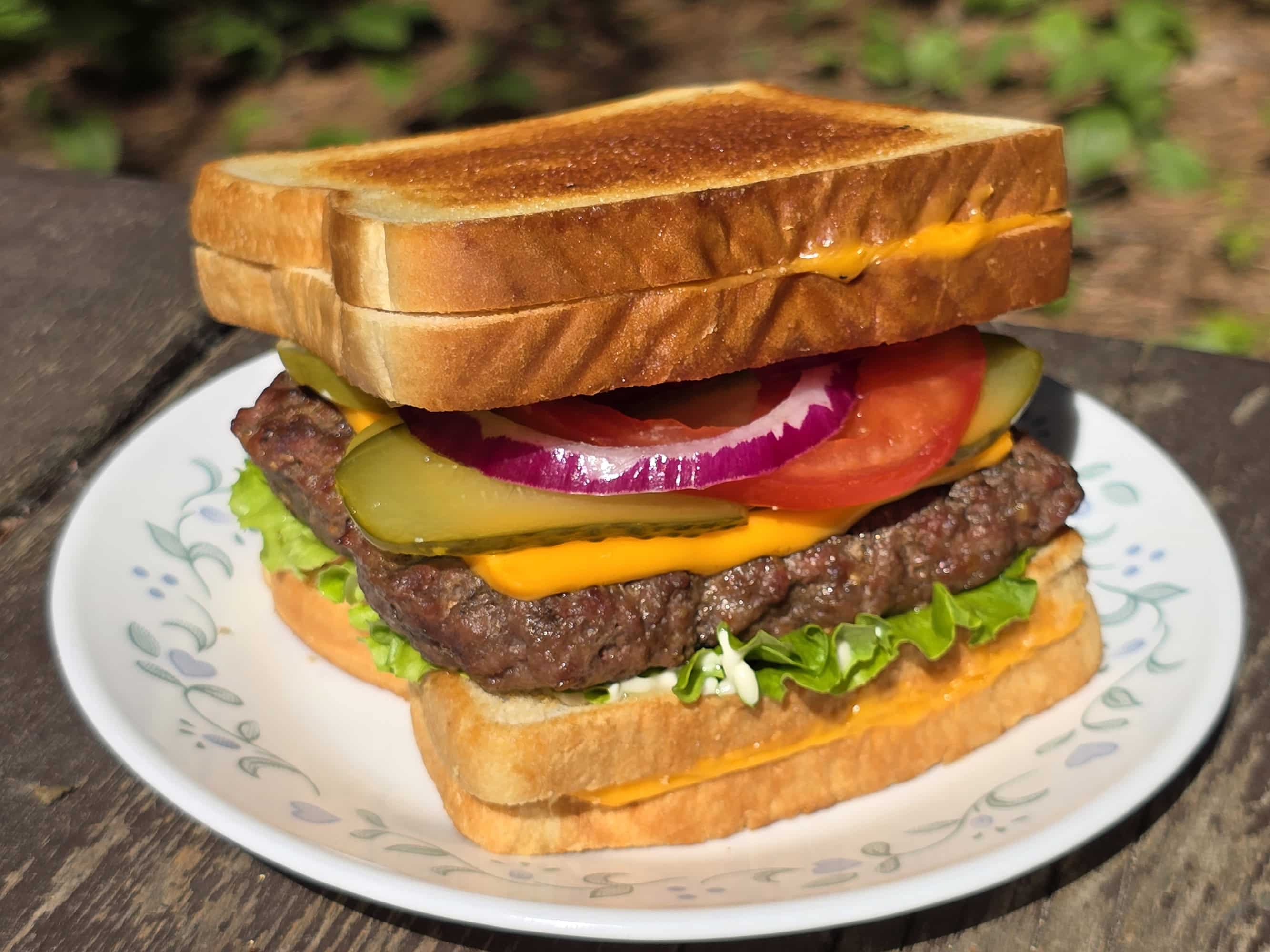 A grilled cheese cheeseburger made with a burger patty ad 2 grilled cheese sandwiches.