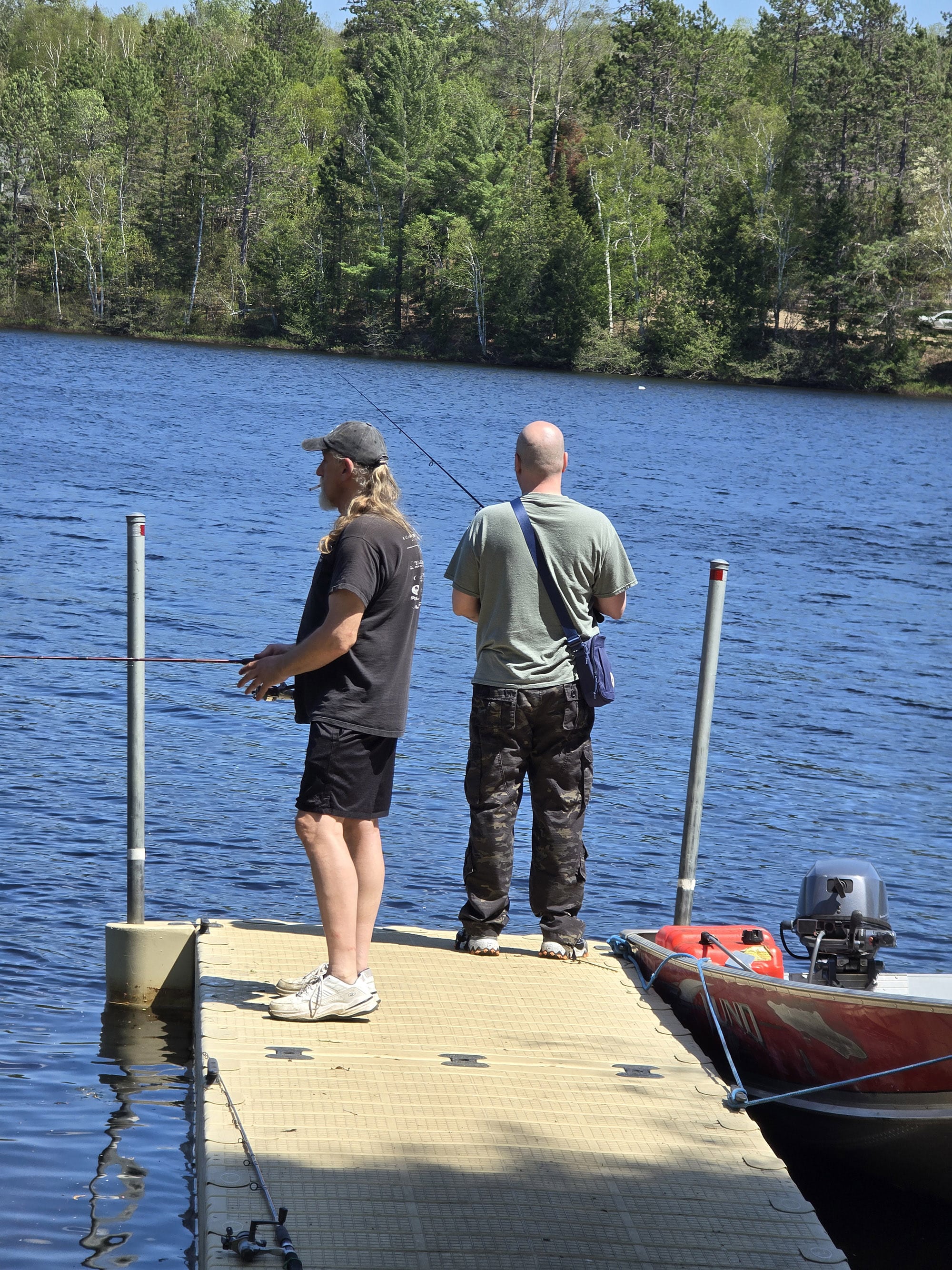 2 men fishing off a dock.