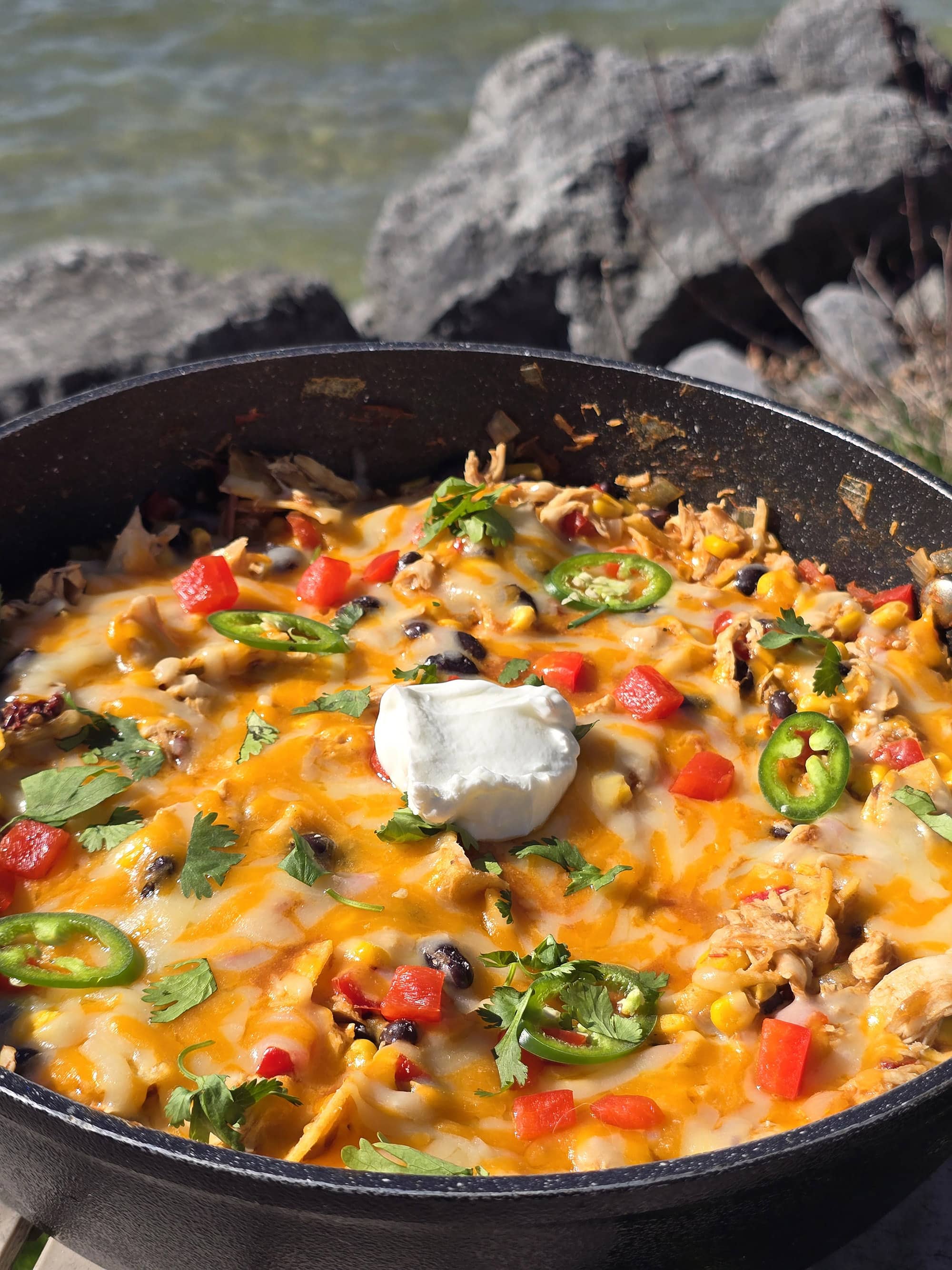 A pan of enchilada bake - red peppers, onions, corn, black beans, chicken, and enchilada sauce with cheese.