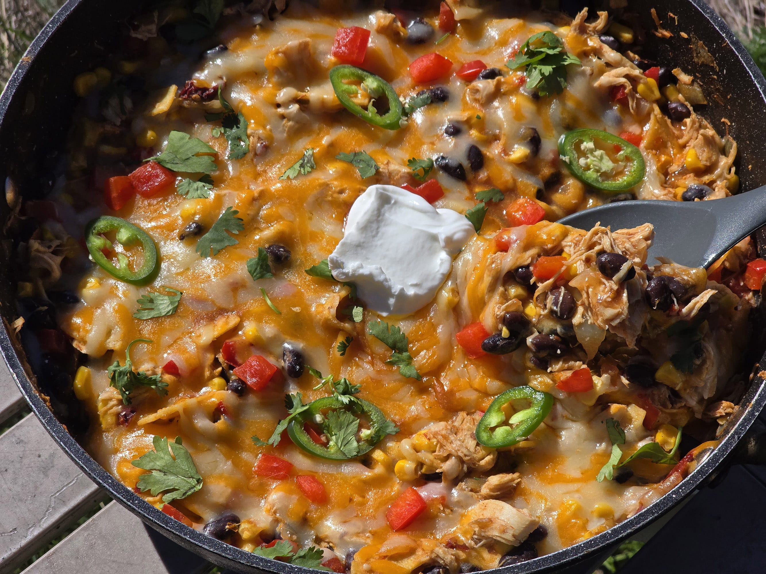 A pan of enchilada bake - red peppers, onions, corn, black beans, chicken, and enchilada sauce with cheese.