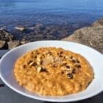 1 bowl of skillet pumpkin oatmeal garnished with pepitas, walnuts, and candied ginger.
