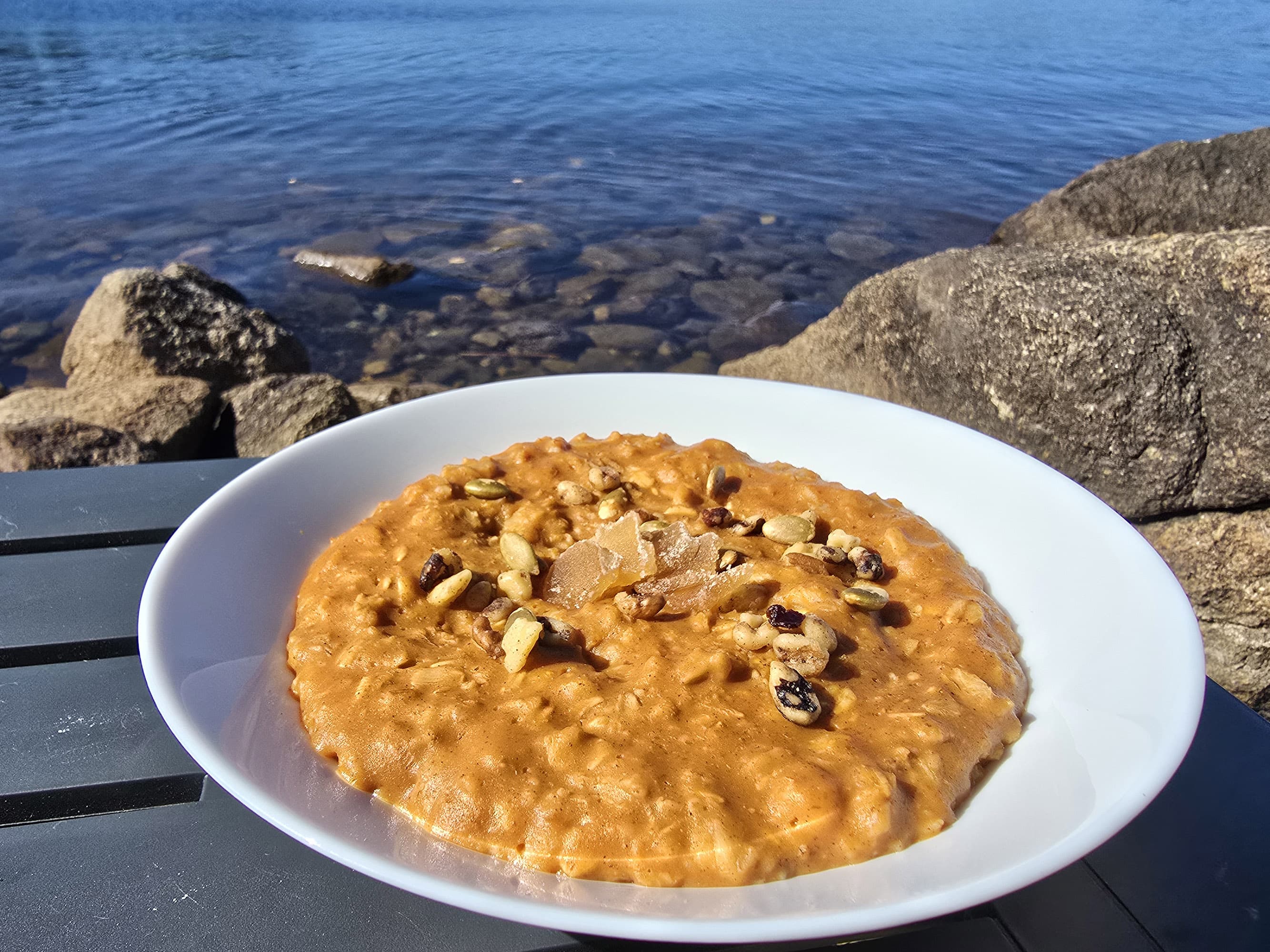 1 bowl of skillet pumpkin oatmeal garnished with pepitas, walnuts, and candied ginger.